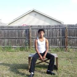 an artist sits at a picnic table in a backyard